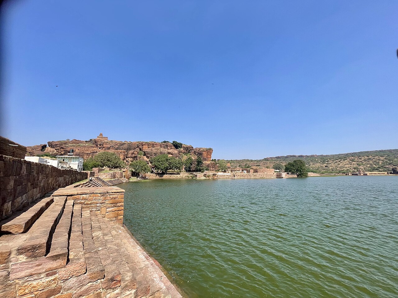 Agastya Lake, red sandstone cliffs and temples in Badami