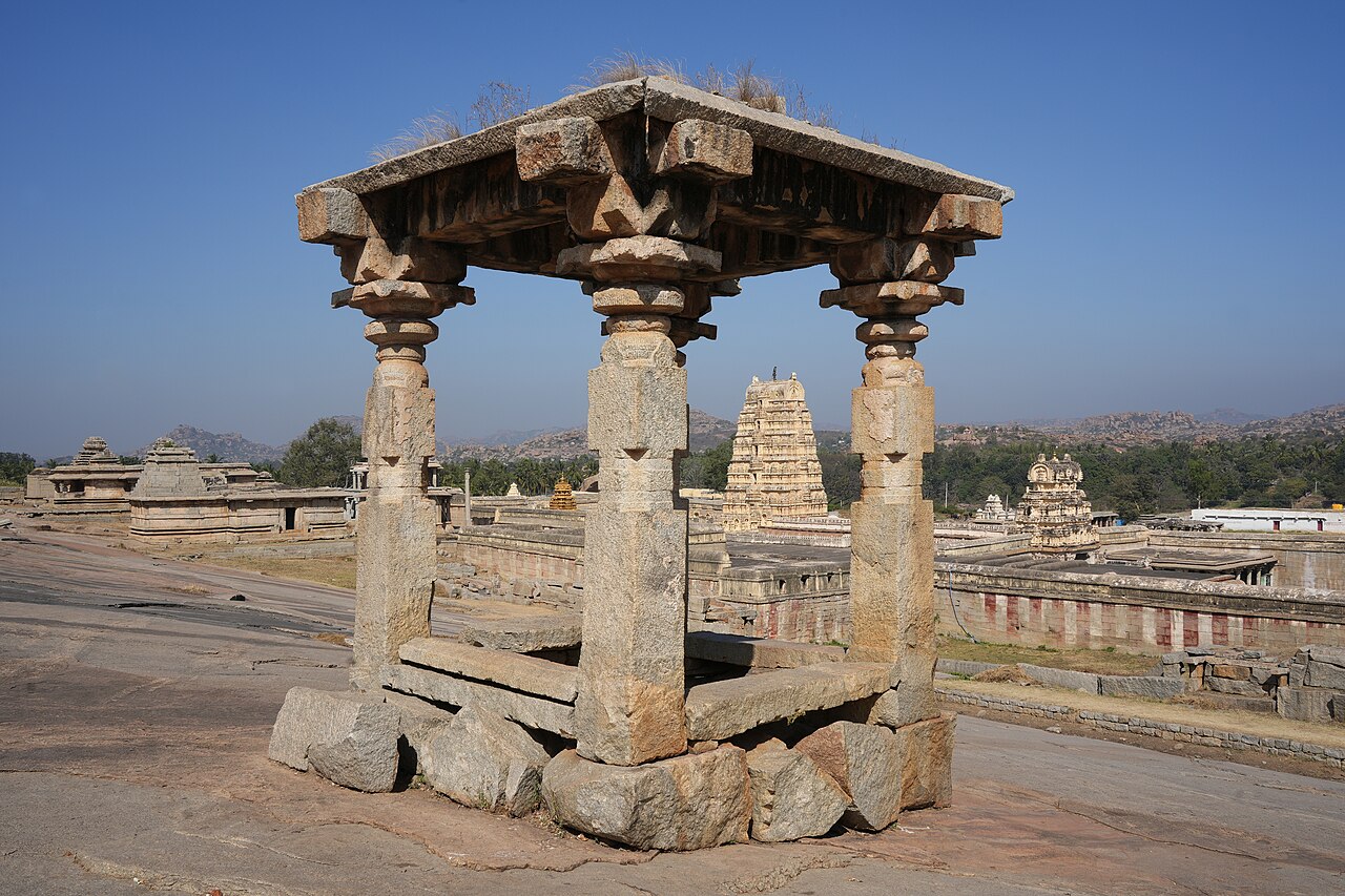 A stone pavilion on Hemakuta Hill overlooking Virupaksha Temple in Hampi